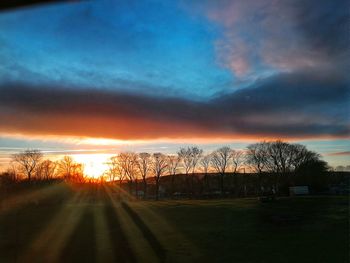 Scenic view of field against sky at sunset