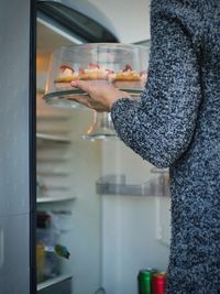 Midsection of woman using refrigerator