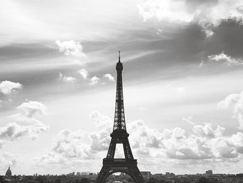 Eiffel tower against cloudy sky