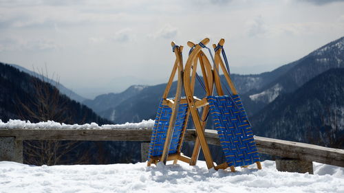 Traditional windmill on snowcapped mountain against sky