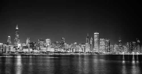 River against illuminated cityscape at night