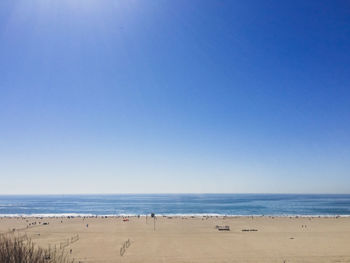 Scenic view of beach against clear blue sky