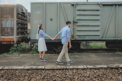 Rear view of people walking on railway station
