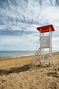 Lifeguard hut on beach against sky