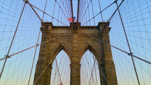 Low angle view of brooklyn bridge against sky in city