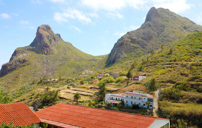 Scenic view of mountains and houses against sky