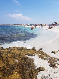 People on beach against sky