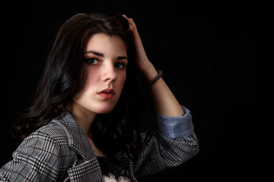 Portrait of a beautiful young woman over black background