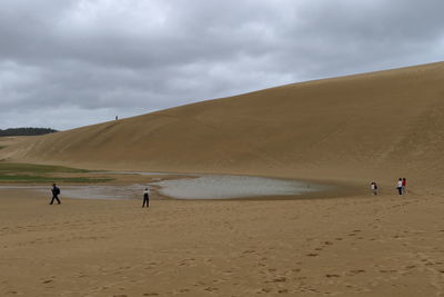 People on beach against sky