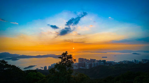 Scenic view of city against sky during sunset