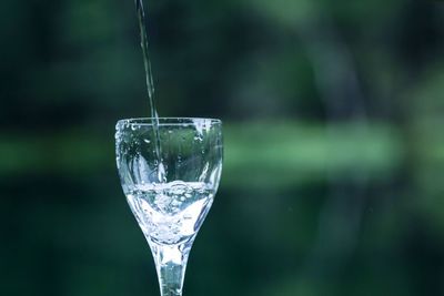 Water pouring in wineglass