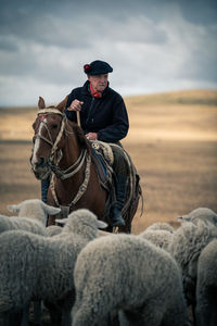 Man riding horse against sky