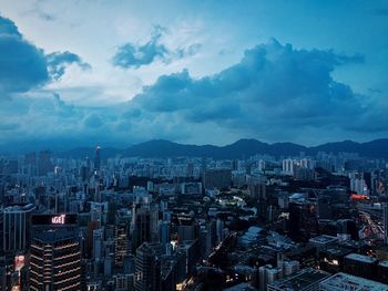 View of cityscape against cloudy sky