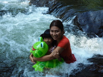 Portrait of happy mother with daughter in river