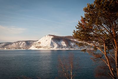 Scenic view of lake by mountain against sky