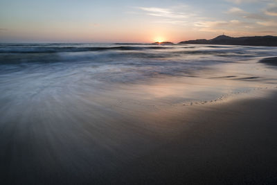 Scenic view of beach against sky during sunset