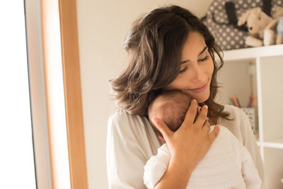 Close-up of mother embracing son at home