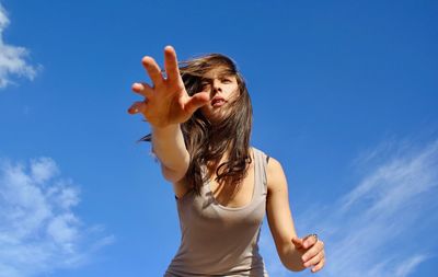 Full length of woman standing against blue sky