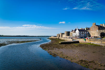 Buildings at beach against blue sky