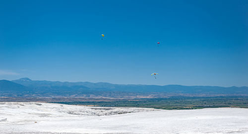 Scenic view of sea and mountains against blue sky