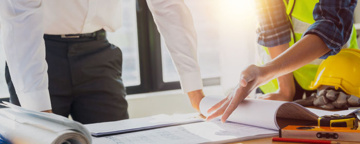 Midsection of business people working at table