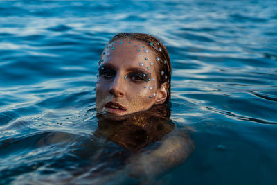 Young woman with golden skin in water