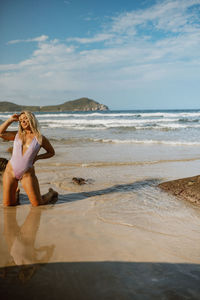 Full length of woman standing at beach against sky