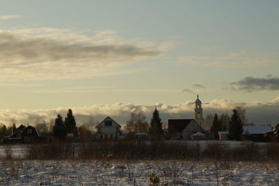 Houses and buildings against sky during sunset