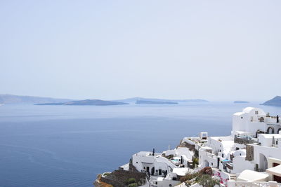 Scenic view of sea and buildings against clear sky