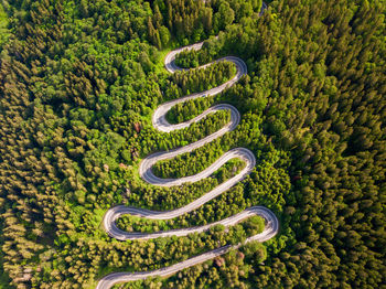 Winding road from high mountain pass, in summer time. aerial view by drone . romania