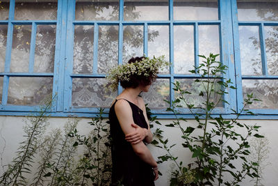 Young woman looking through window