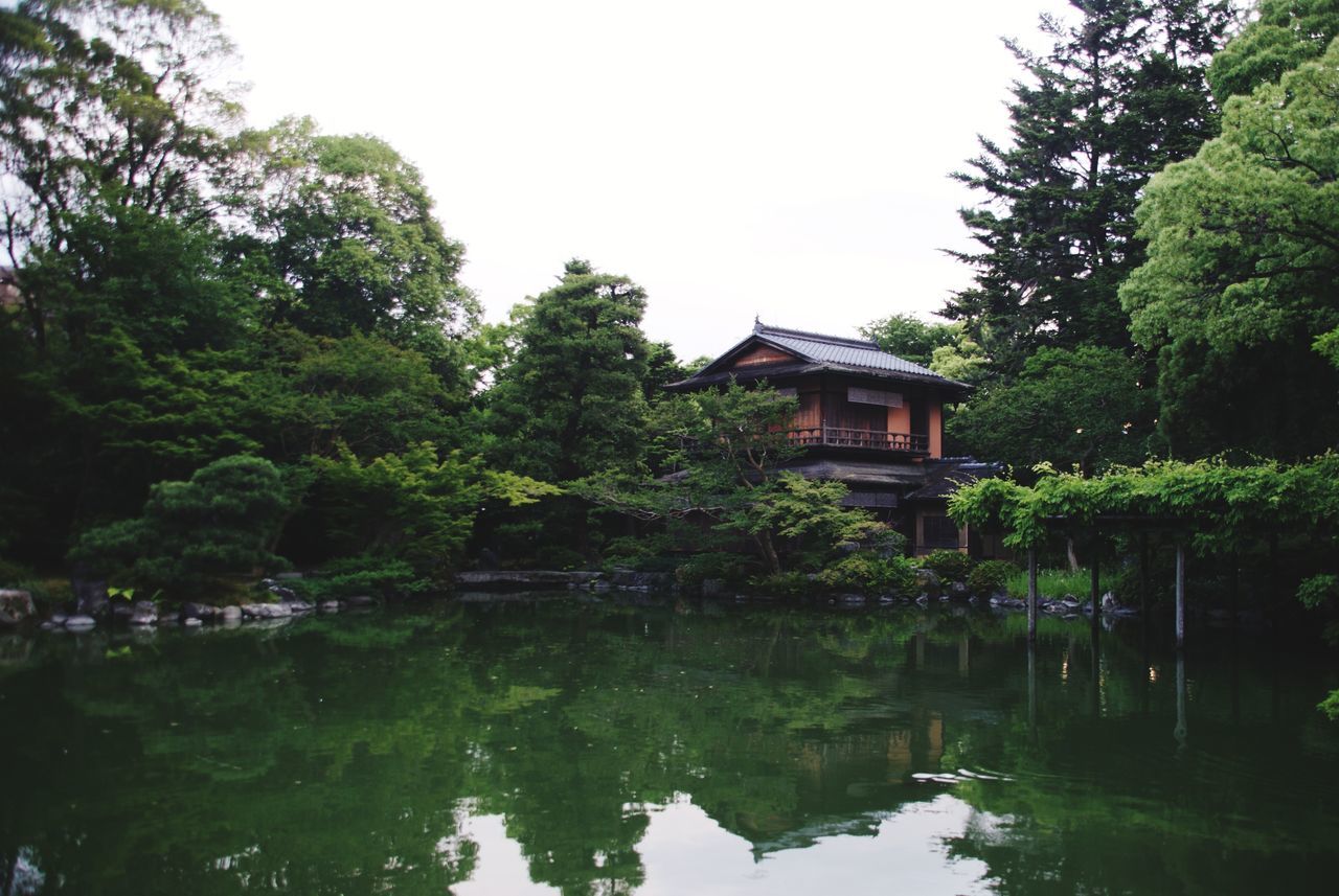 reflection, tree, lake, water, plant, architecture, built structure, building exterior, nature, waterfront, building, growth, house, green color, no people, tranquility, day, sky, beauty in nature, outdoors