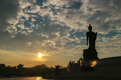 Silhouette of statue at sunset