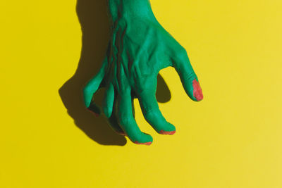 Low section of woman against yellow background