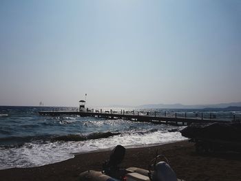 Low section of person on beach against clear sky