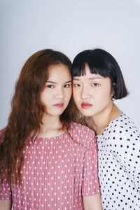 Portrait of lesbian couple against gray background