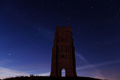 Low angle view of illuminated castle against sky at night