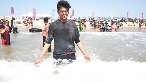 Portrait of smiling young woman standing at beach