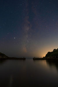 Scenic view of lake against sky at night