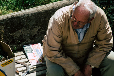 Midsection of man sitting outdoors