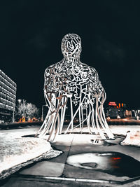 Illuminated building during winter against sky at night