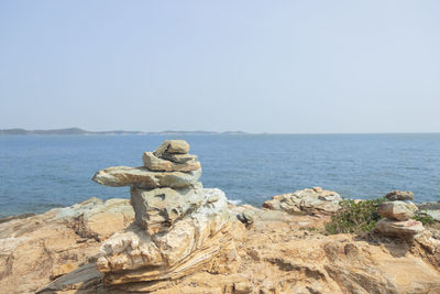 Scenic view of rocks on beach against clear sky