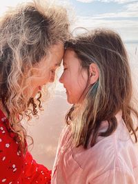 Side view of young woman and her daughter looking to each other