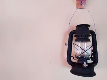 Close-up of illuminated light bulb against wall