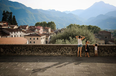 Man standing by houses against mountains