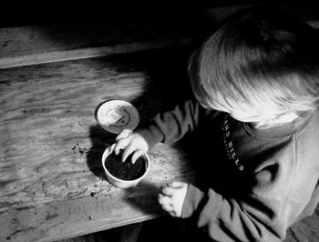 High angle view of boy with dirt on table