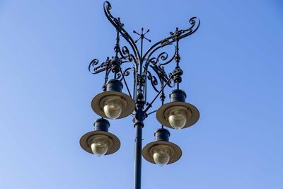 Low angle view of street light against blue sky