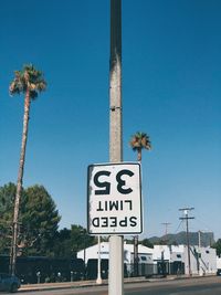 Low angle view of road sign against blue sky