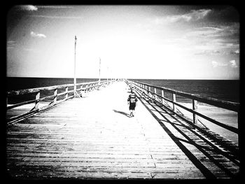 People on pier at sea