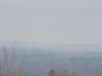 Scenic view of landscape against sky at foggy weather